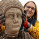 Archaeologist Rachel Wood positioning a stone bust atop its corresponding torso.